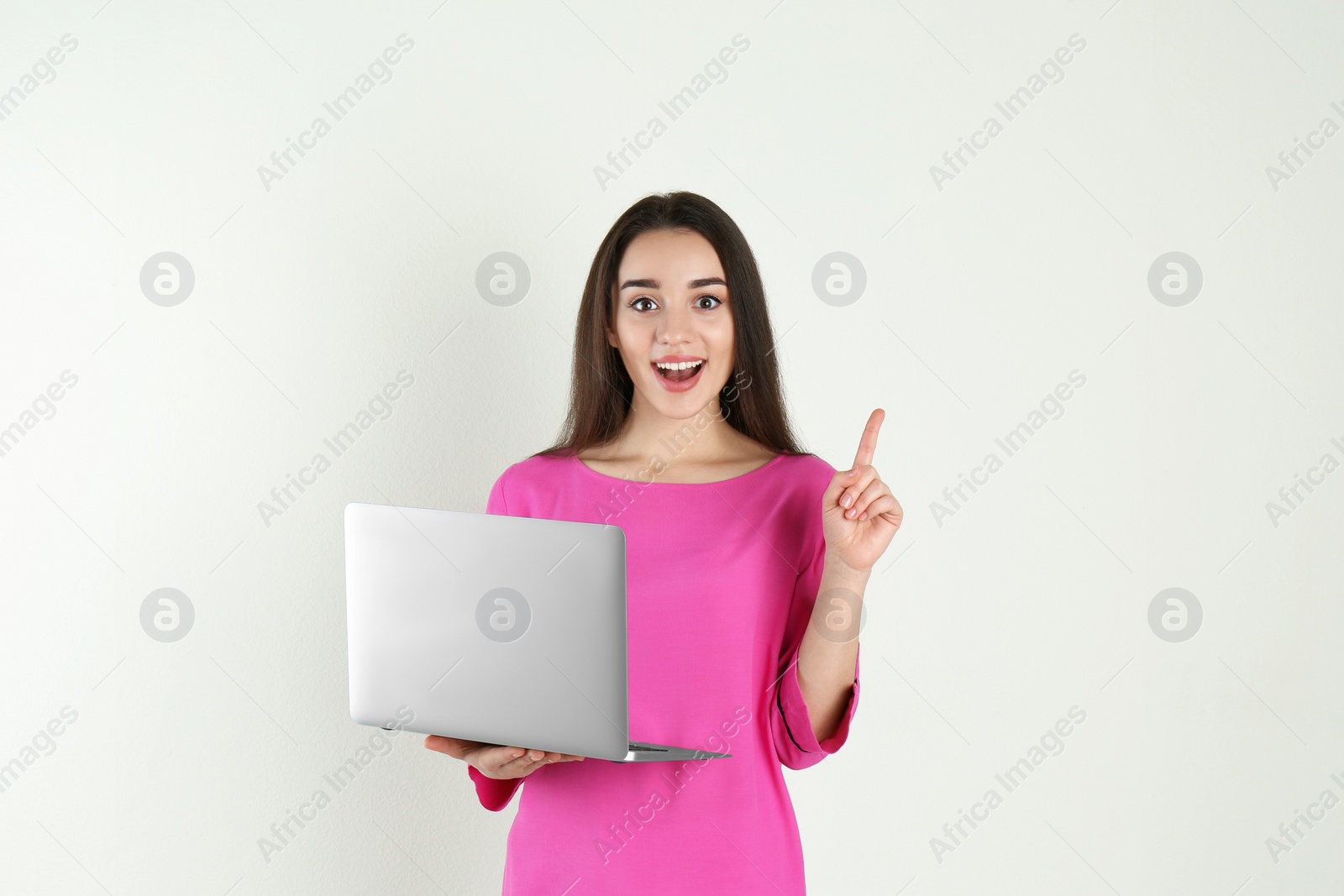 Photo of Portrait of young woman in casual outfit with laptop on light background