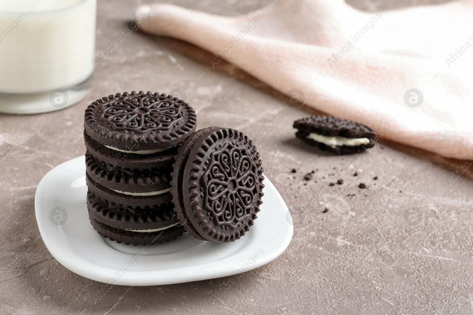 Photo of Plate with chocolate and cream cookies on table. Space for text