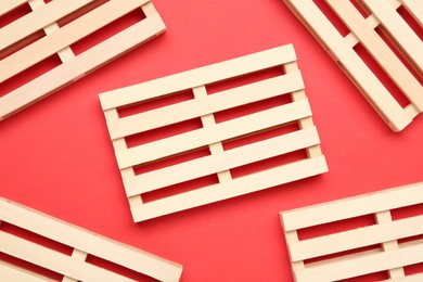 Wooden pallets on red background, flat lay