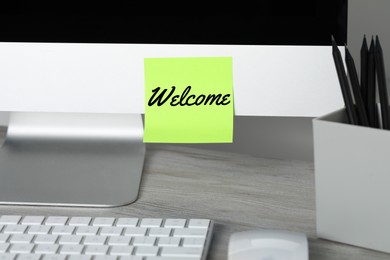 Image of Sticky note with word Welcome on computer monitor in office