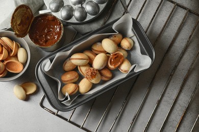 Delicious walnut shaped cookies with condensed milk on grey table, flat lay