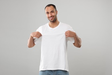 Photo of Man wearing white t-shirt on gray background