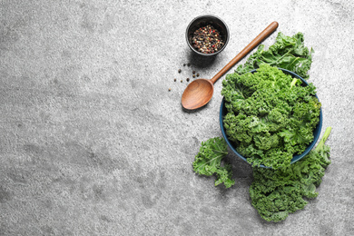 Fresh kale leaves and pepper on grey table, flat lay. Space for text