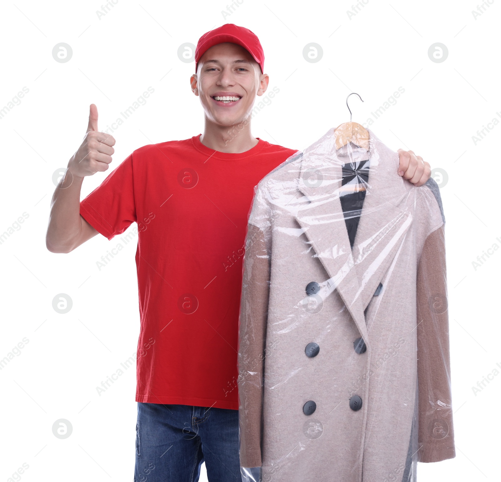 Photo of Dry-cleaning delivery. Happy courier holding coat in plastic bag and showing thumbs up on white background