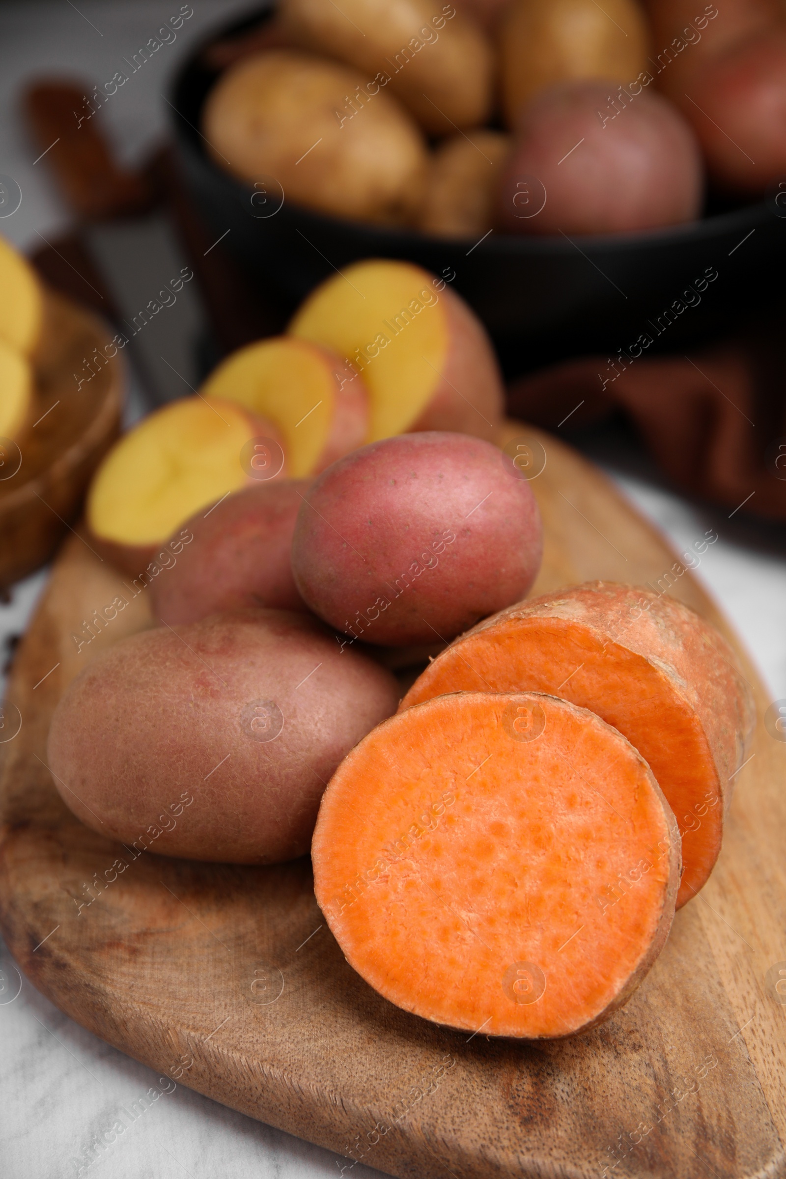 Photo of Different types of fresh potatoes on wooden board