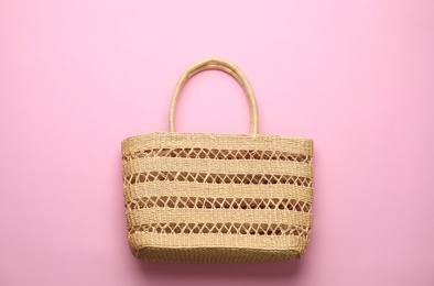 Photo of Elegant woman's straw bag on pink background, top view