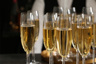 Glasses of champagne and waiter in restaurant, closeup