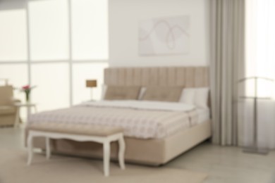 Blurred view of stylish hotel bedroom interior with modern furniture