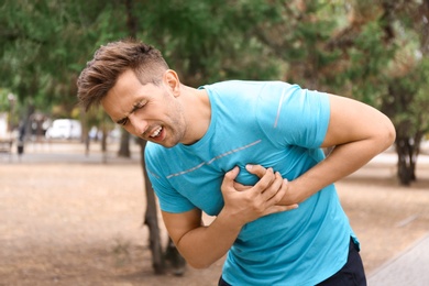 Young man having heart attack while running in park