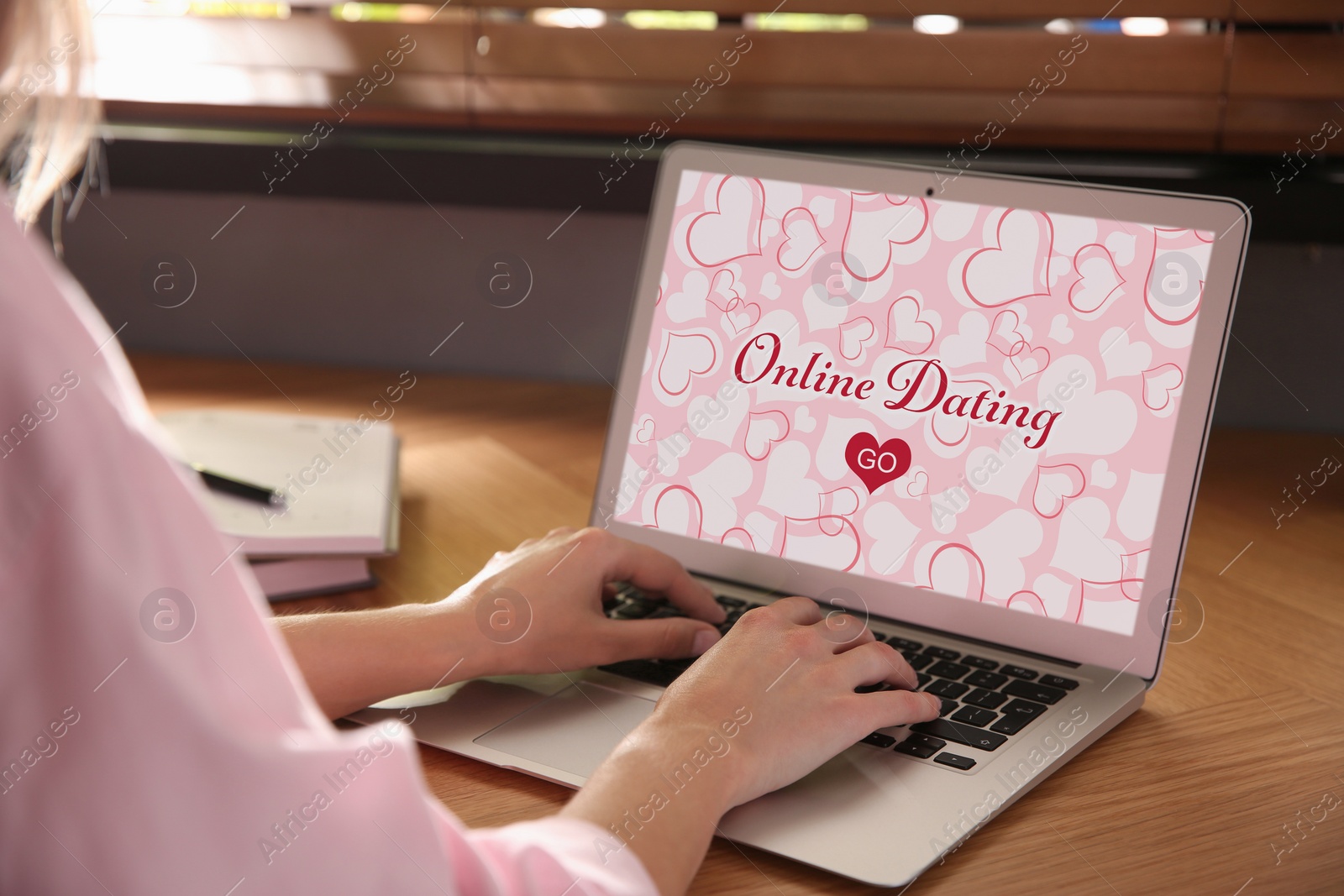 Image of Woman visiting dating site via laptop at table, closeup