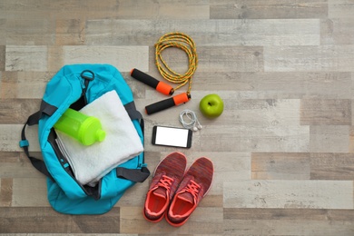 Photo of Flat lay composition with sports bag on wooden floor, top view