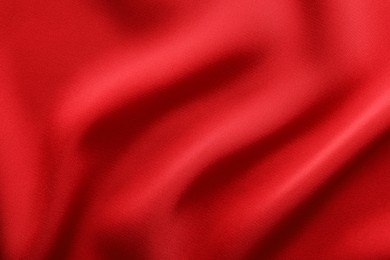 Photo of Crumpled red silk fabric as background, top view