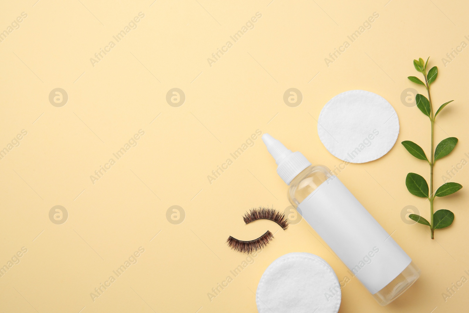 Photo of Flat lay composition with makeup remover and false eyelashes on yellow background. Space for text