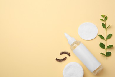 Flat lay composition with makeup remover and false eyelashes on yellow background. Space for text