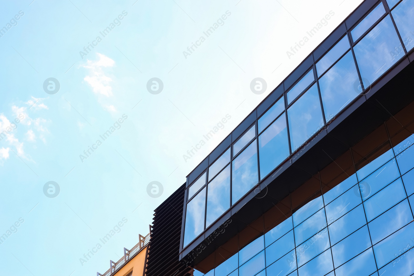 Photo of Low angle view of modern building with tinted windows against blue sky