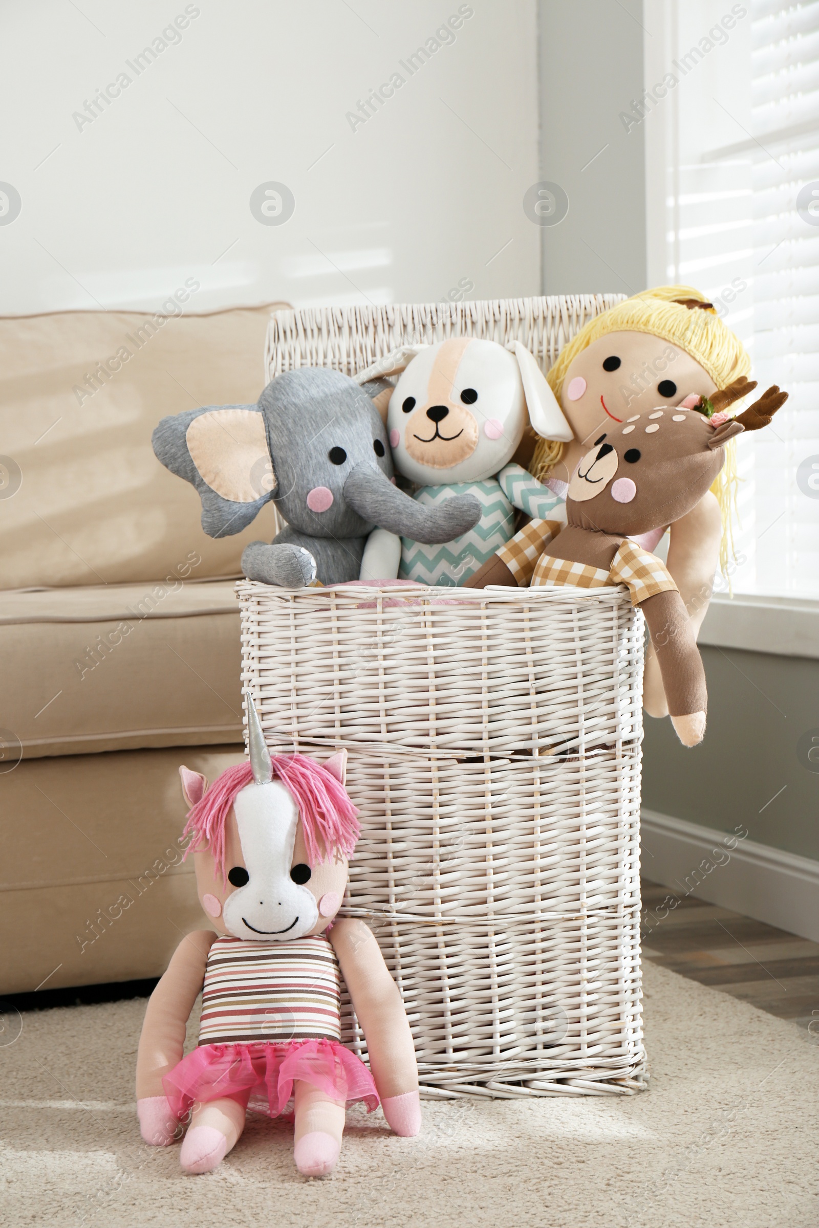 Photo of Funny stuffed toys and basket in children's room. Interior decor