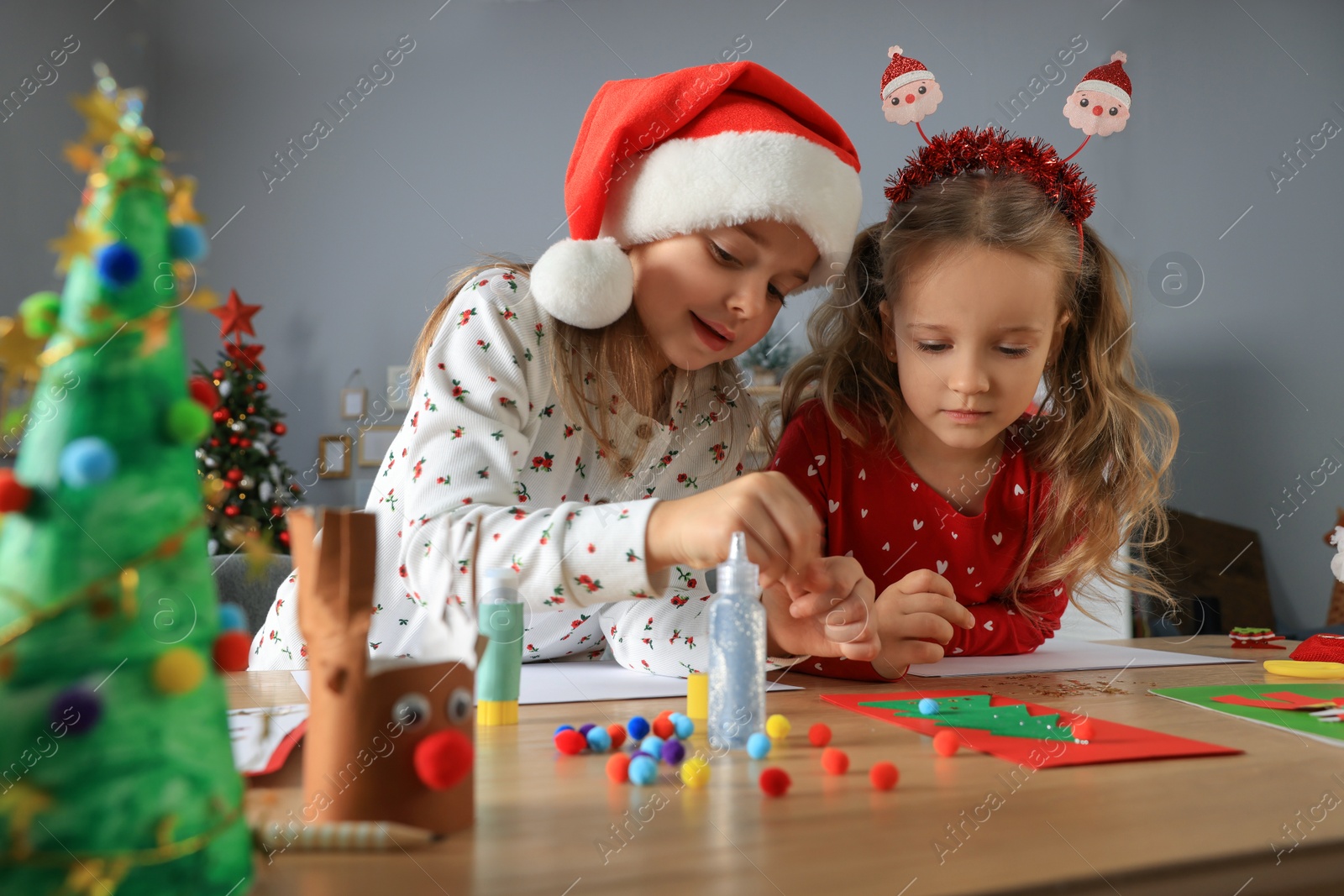 Photo of Cute little children making beautiful Christmas greeting cards at home