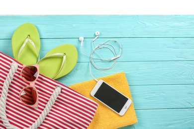 Flat lay composition with beach accessories on wooden background. Space for text