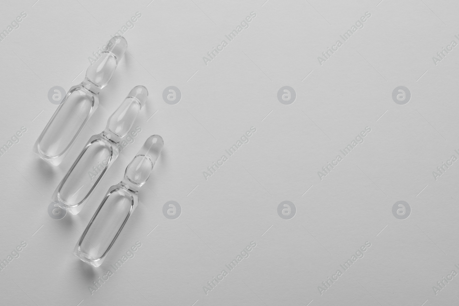 Photo of Pharmaceutical ampoules with medication on white background, flat lay. Space for text