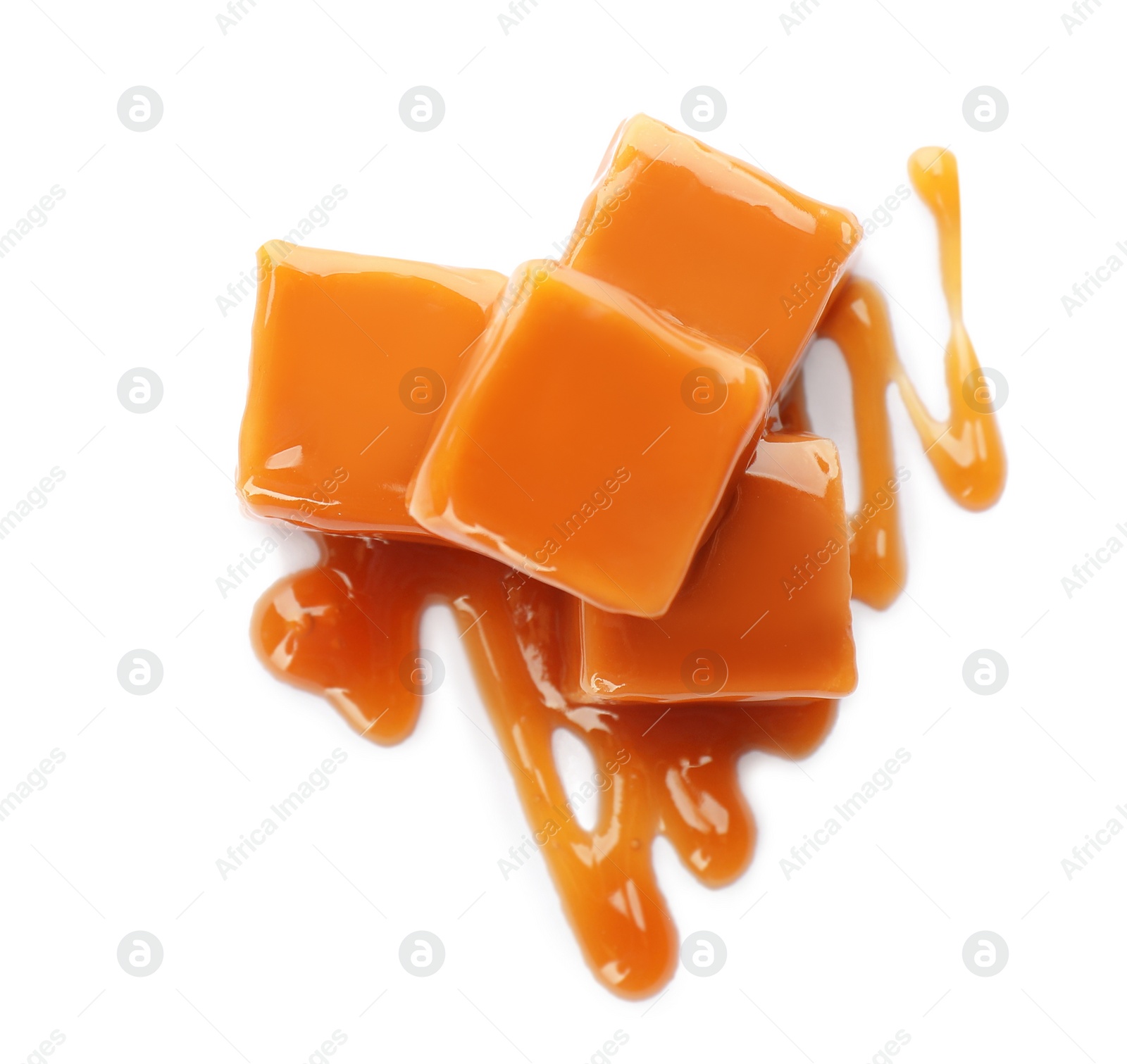 Photo of Heap of sweet caramel candies with topping isolated on white, top view