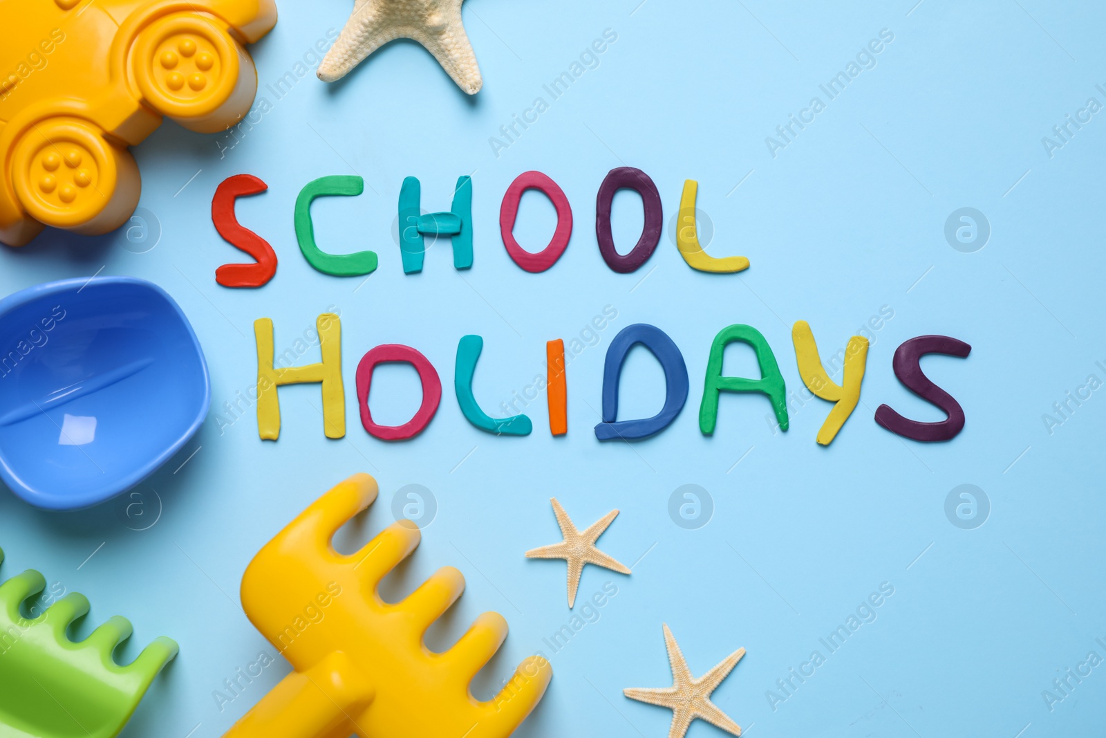 Photo of Flat lay composition with phrase School Holidays made of modeling clay on light blue background