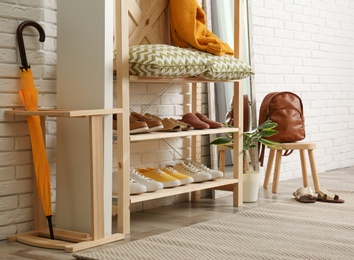 Photo of Cozy hallway interior with wooden shelving unit. Stylish design idea