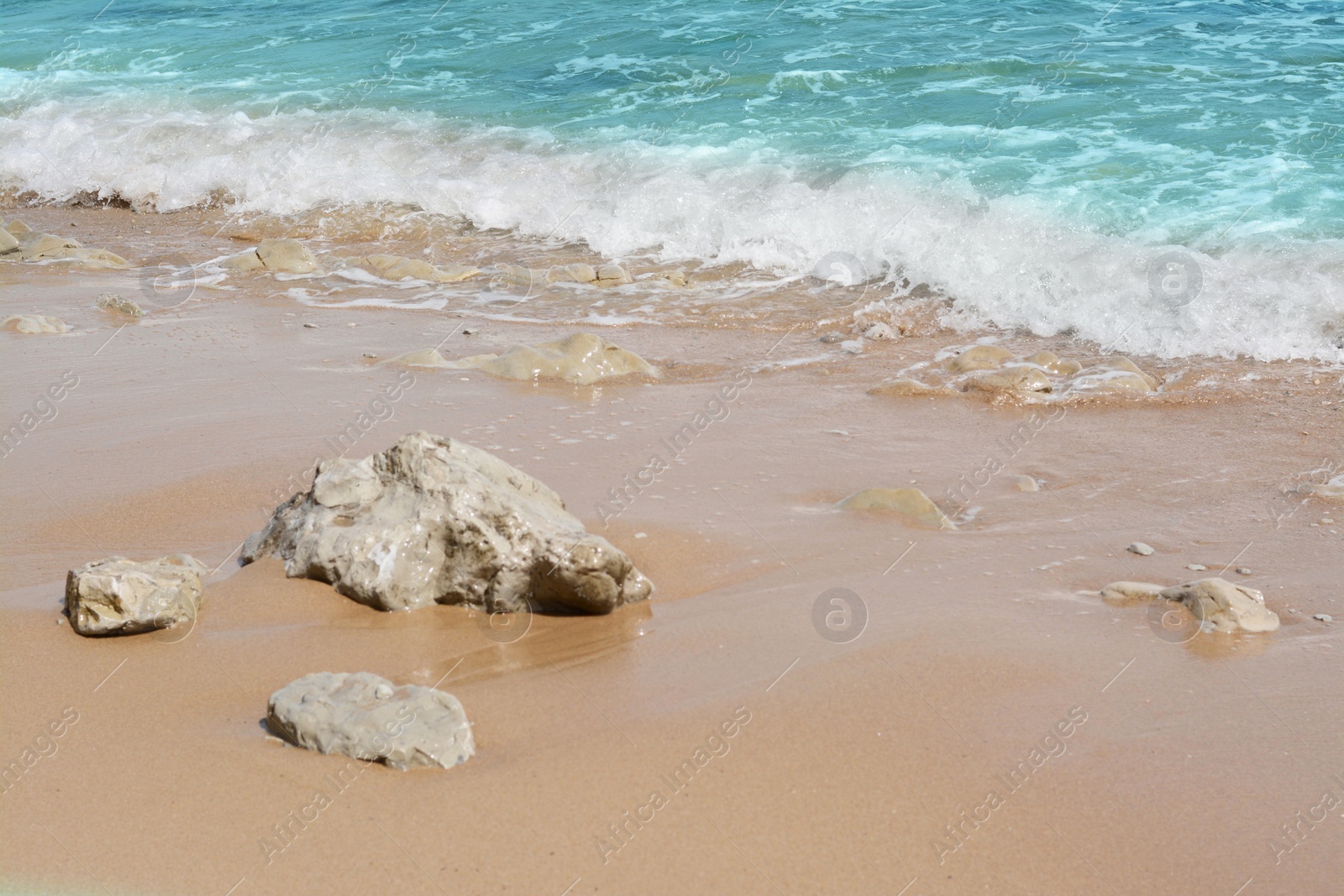 Photo of Beautiful view of sandy beach with rocks and sea. Summer vacation