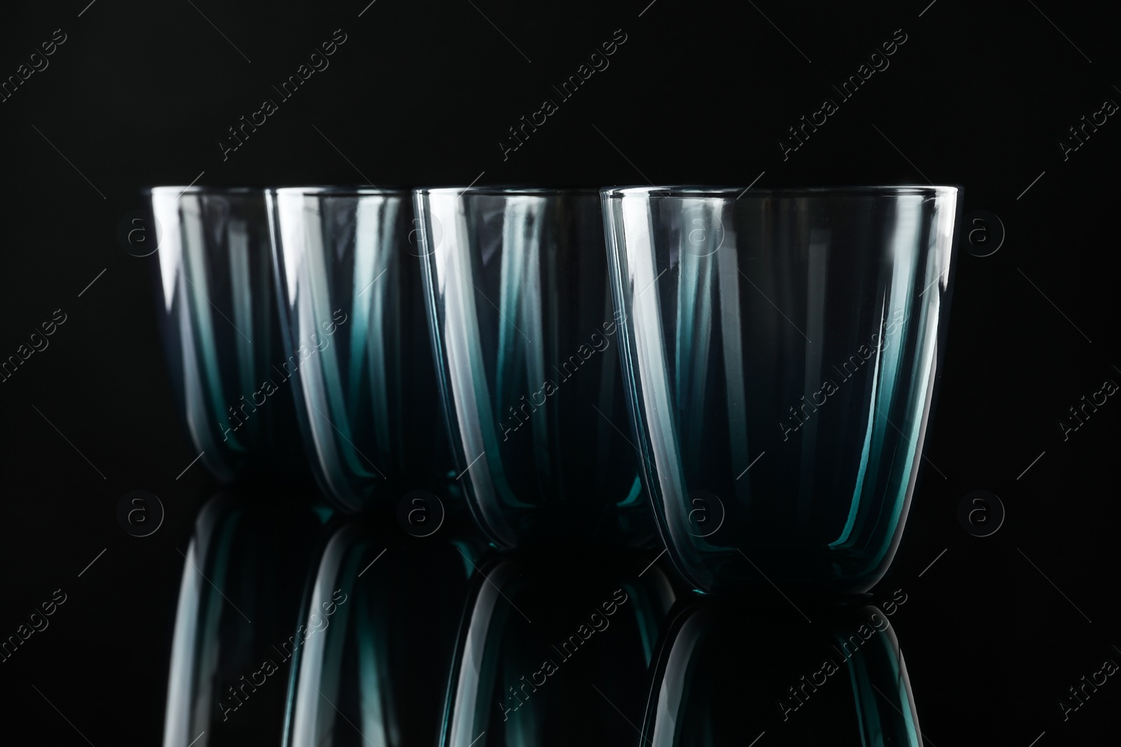 Photo of Set of empty colorful glasses on black background