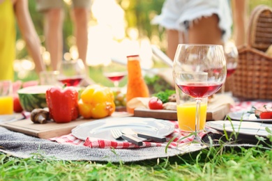 Photo of Blanket with food prepared for summer picnic outdoors, closeup
