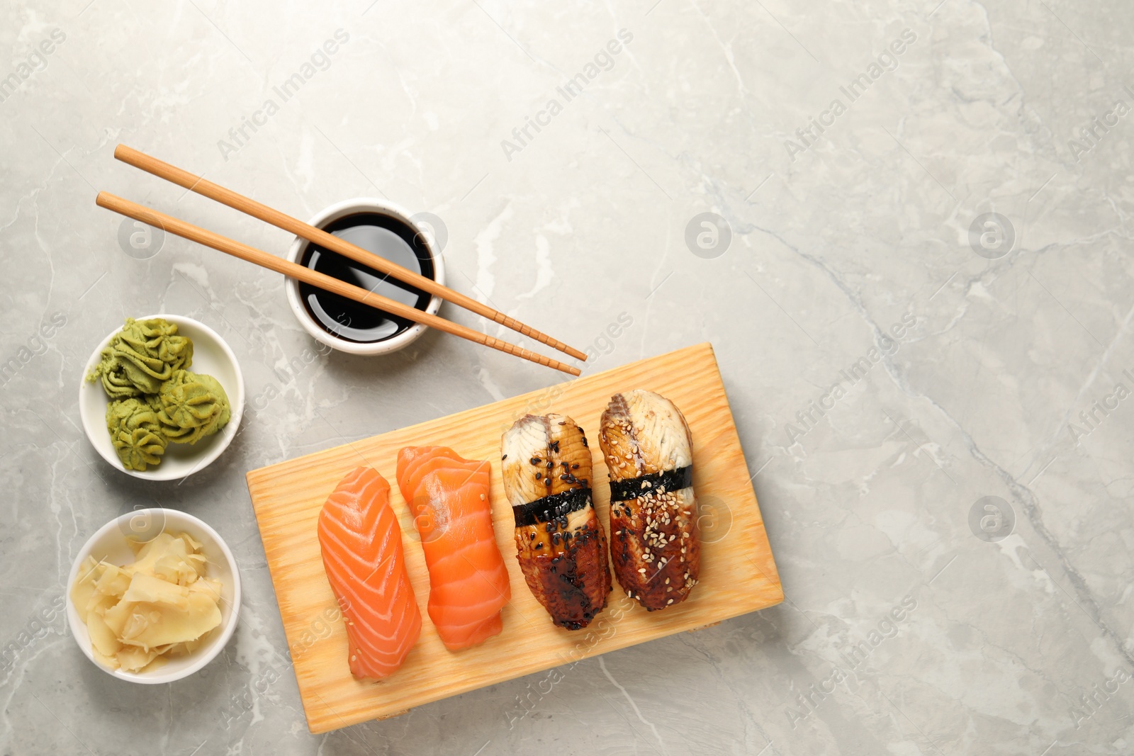 Photo of Delicious nigiri sushi served on light grey marble table, flat lay. Space for text