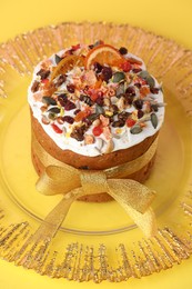 Traditional Easter cake with dried fruits on yellow background