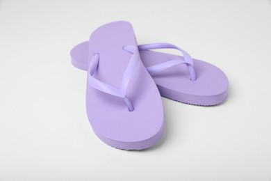 Photo of Stylish violet flip flops on white background
