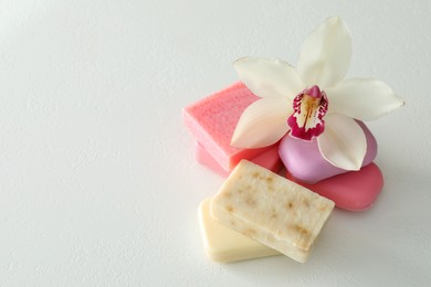 Photo of Soap bars and lily on white table, above view. Space for text