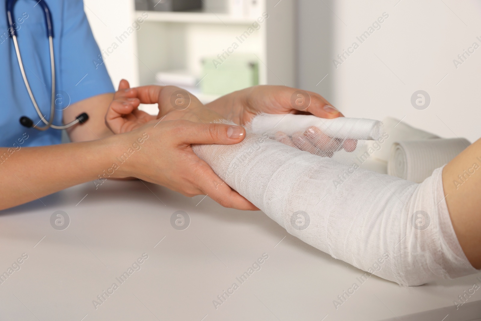 Photo of Doctor applying bandage onto patient's arm in hospital, closeup