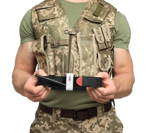 Soldier in military uniform holding medical tourniquet on white background, closeup