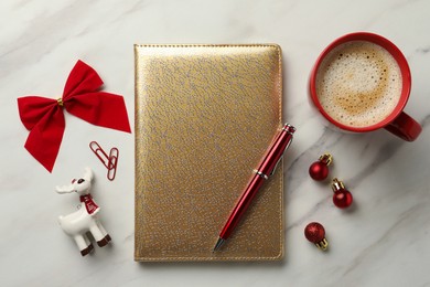 Stylish planner, cup of aromatic coffee and Christmas decor on white marble background, flat lay. New Year aims