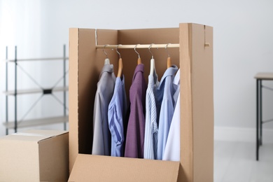 Wardrobe box with clothes on hangers indoors