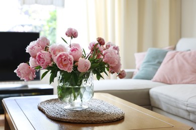 Beautiful pink peonies in vase on table at home, space for text. Interior design