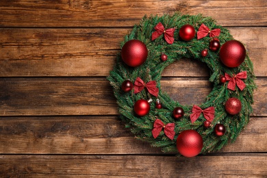 Photo of Beautiful Christmas wreath on wooden background, top view. Space for text