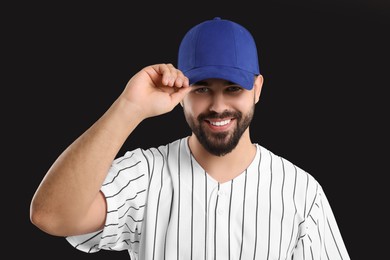 Man in stylish blue baseball cap on black background