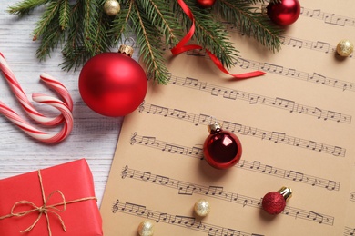 Photo of Flat lay composition with Christmas decorations and music sheets on white wooden table