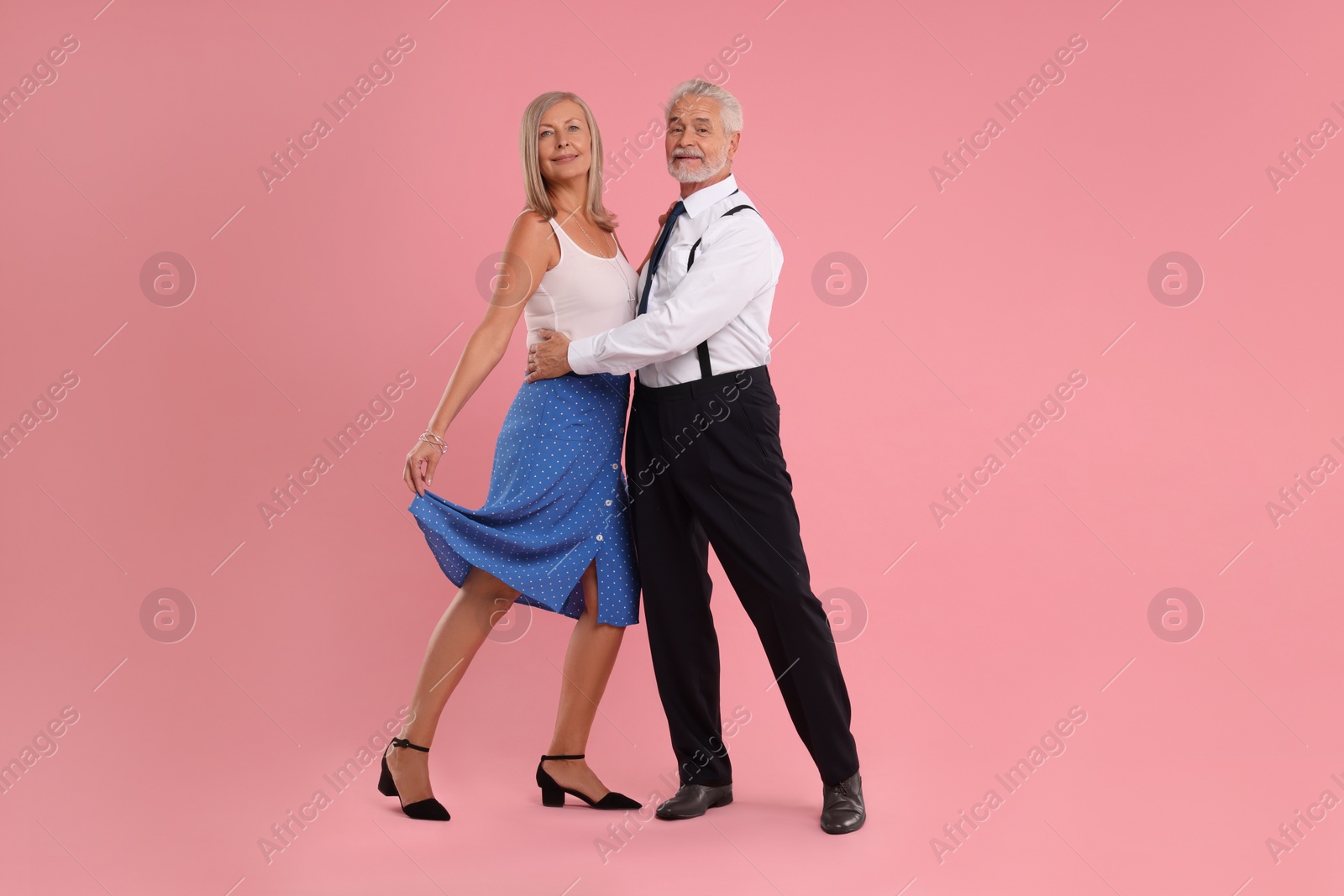 Photo of Senior couple dancing together on pink background