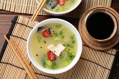 Photo of Bowls of delicious miso soup with tofu served on table, flat lay