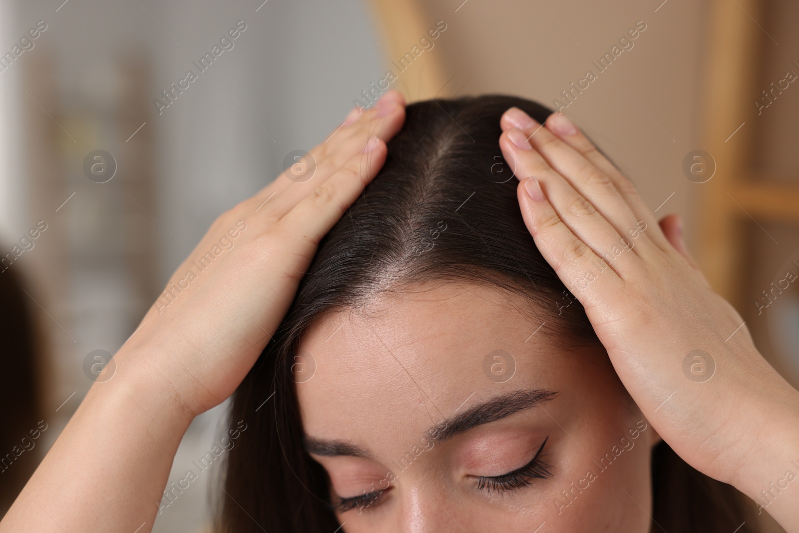 Photo of Woman examining her hair and scalp on blurred background, closeup