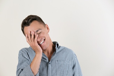 Photo of Portrait of handsome young man laughing on white background. Space for text