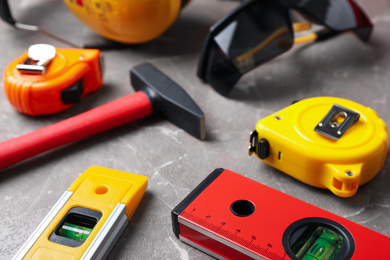 Many different construction tools on grey marble table