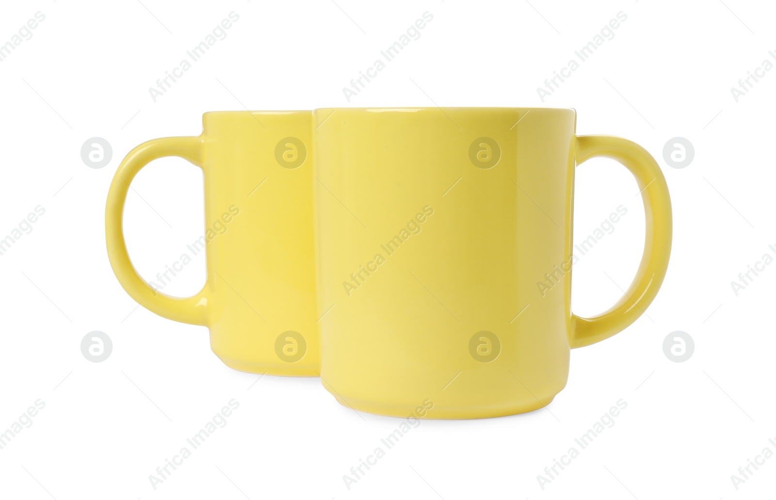 Photo of Two yellow ceramic mugs isolated on white