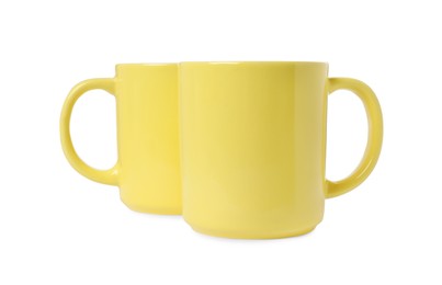 Photo of Two yellow ceramic mugs isolated on white