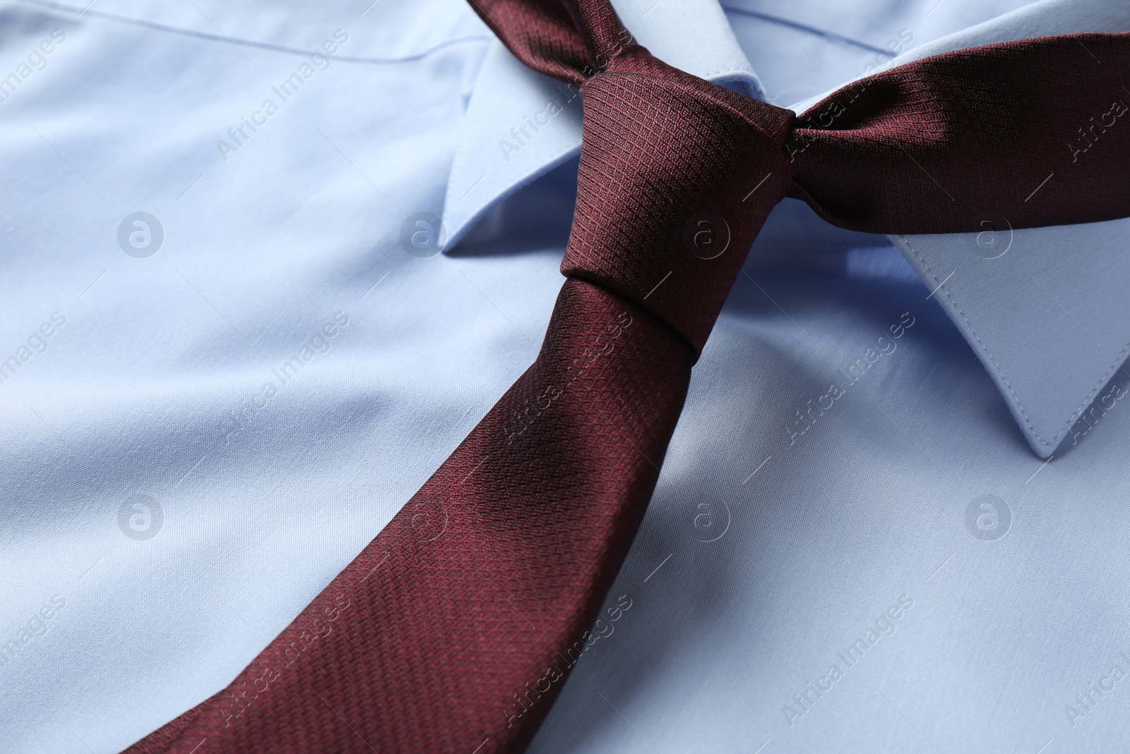 Photo of Classic male necktie on blue shirt, closeup