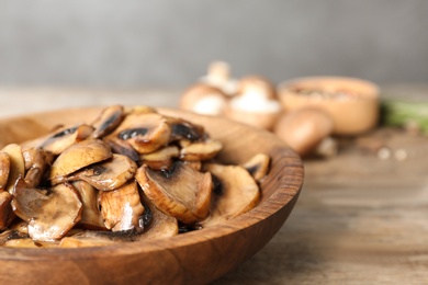 Photo of Plate of fried mushrooms on table, closeup. Space for text